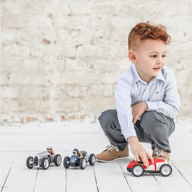 Enfant avec une petite voiture jouet Racing Car rouge Baghera