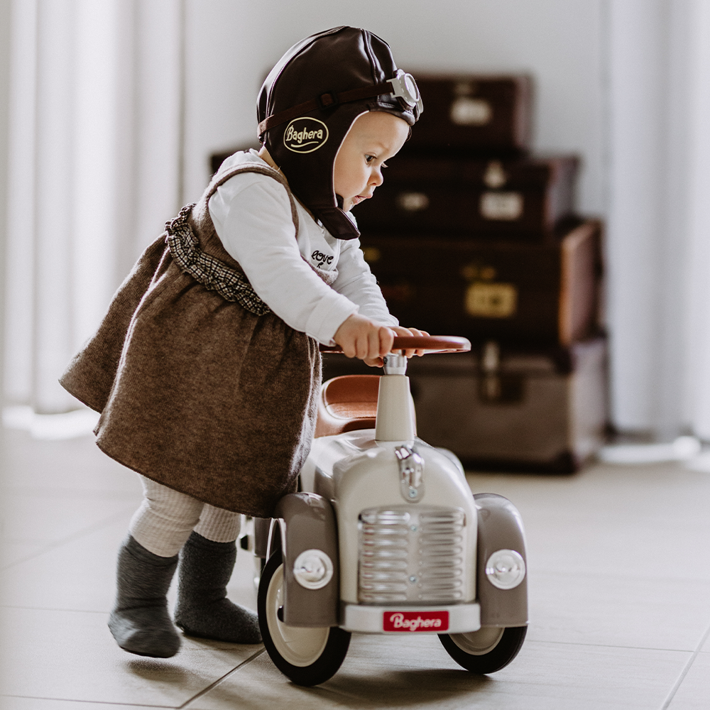 petite fille jouant avec un porteur beige