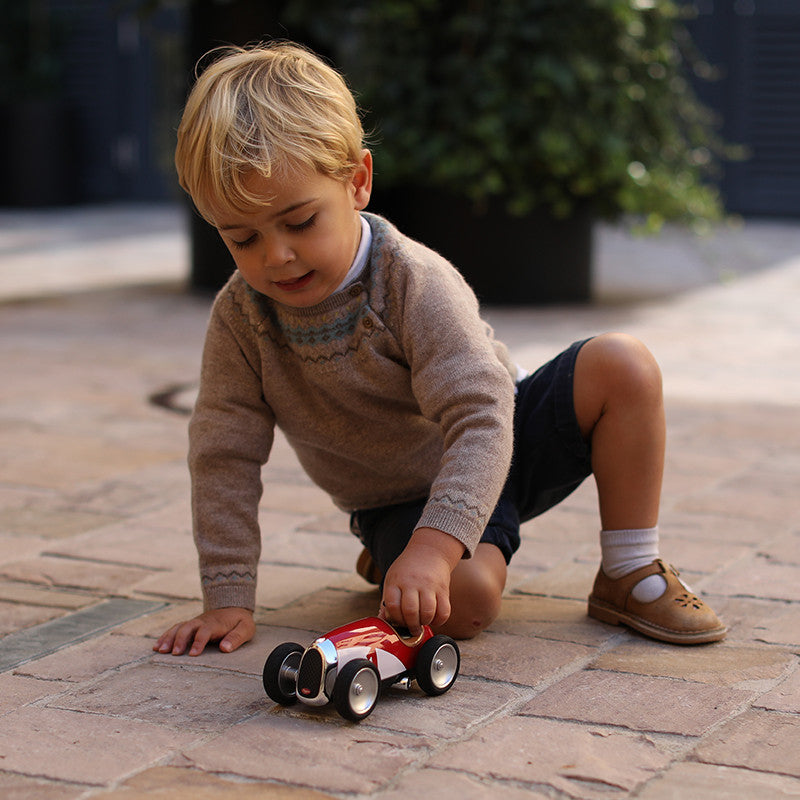 Enfant jouant avec une Racing Car rouge Baghera